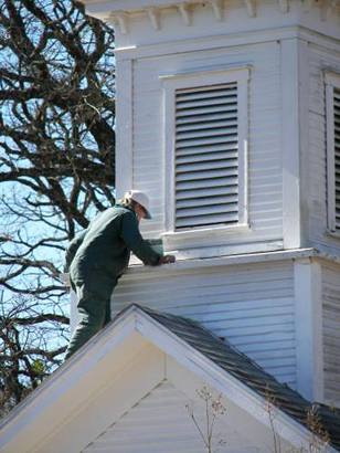 Man repairing Cottonwood  Baptist Church steeple, Gray's Prairie, Texas