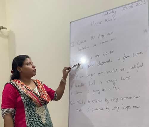 Volunteer instructor teaching Engish to underprivileged kids in Pakistan