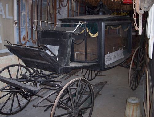 a horse drawn hearse with a wicker casket