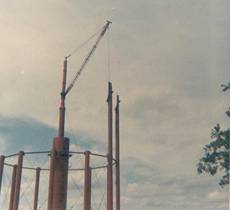 Water tower construction using a guyless derrick crane