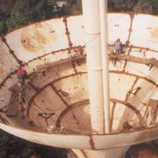 Close up view of man working on water tower tank